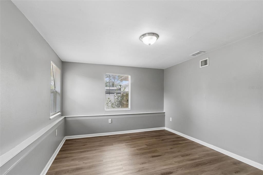 9931 110th Street Seminole, FL 33772 - Photo 25 of 52 an empty room with wooden floor and windows
