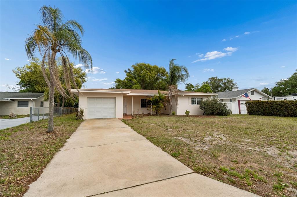 9931 110th Street Seminole, FL 33772 - Photo 3 of 52 a front view of a house with a yard and potted plants
