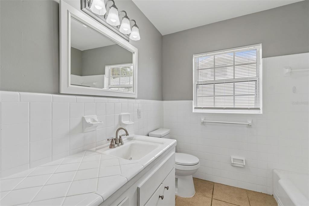 9931 110th Street Seminole, FL 33772 - Photo 35 of 52 a bathroom with a sink a toilet and a mirror