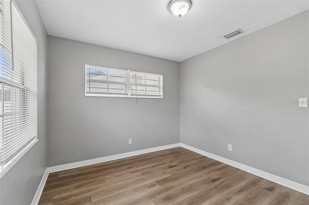 9931 110th Street Seminole, FL 33772 - Photo 37 of 52 an empty room with wooden floor and windows
