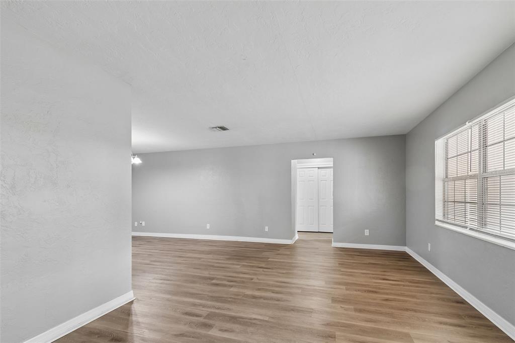 9931 110th Street Seminole, FL 33772 - Photo 8 of 52 an empty room with wooden floor and windows