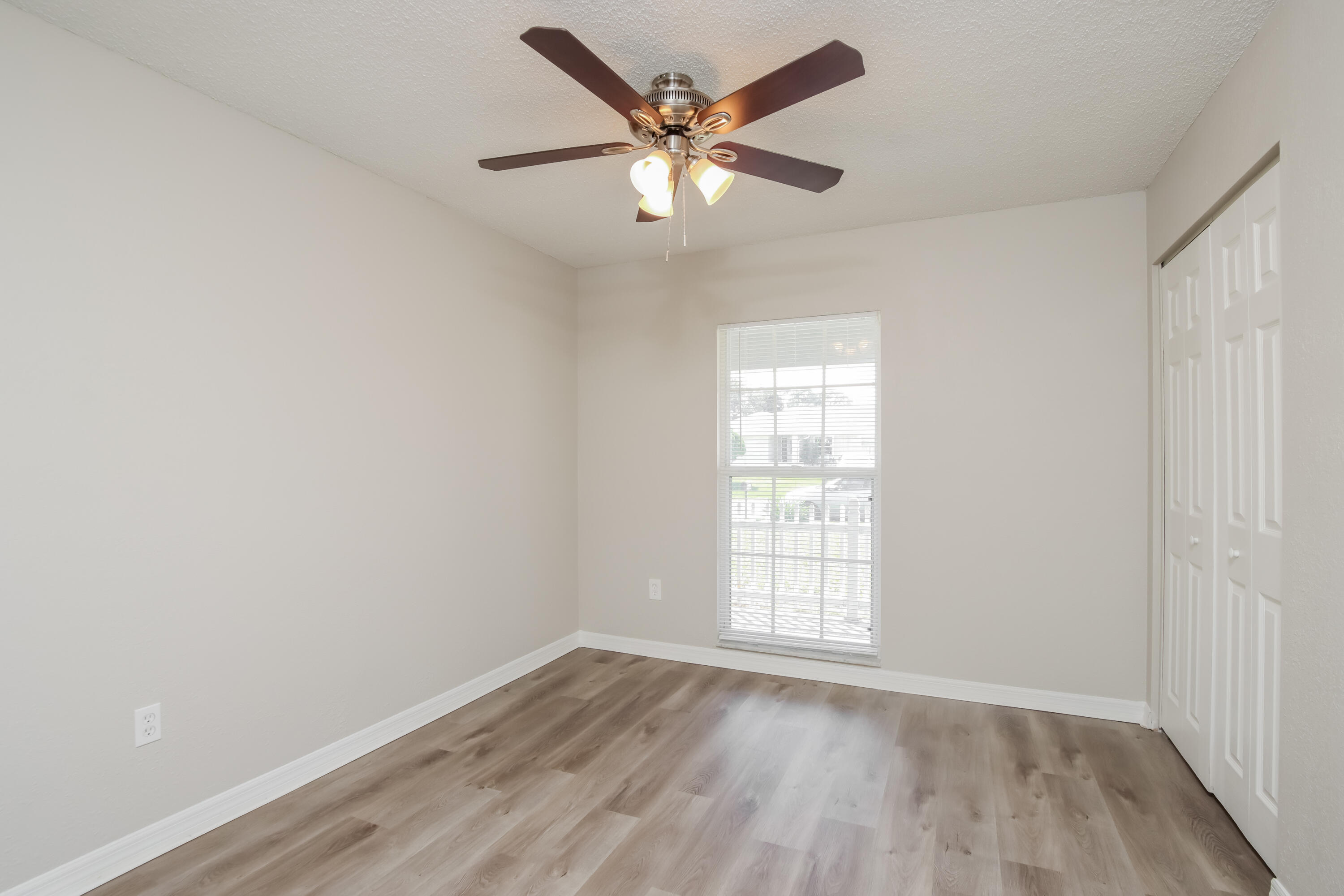1195 Cotton Road Northeast Palm Bay, FL 32905 - Photo 12 of 17 an empty room with wooden floor and windows