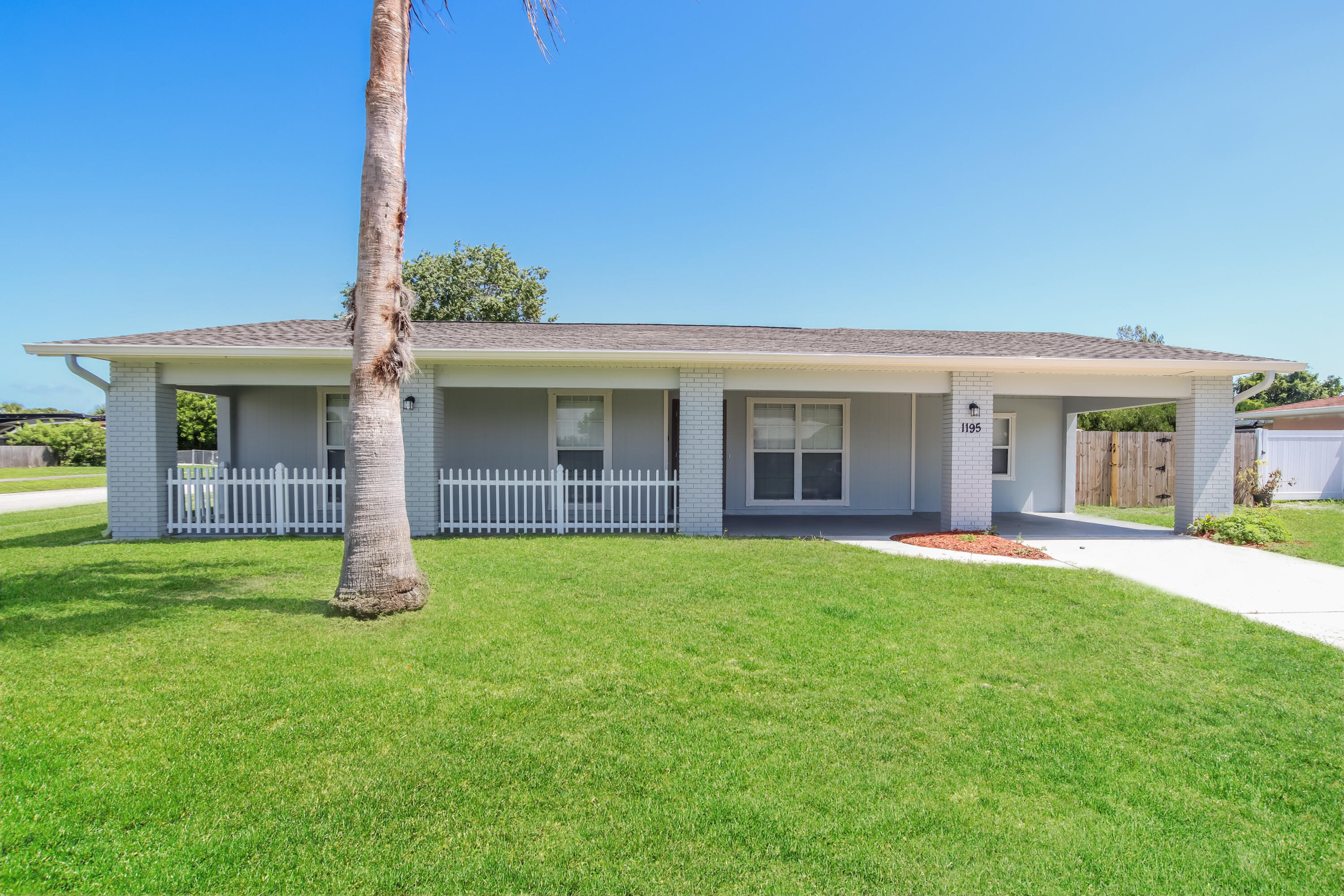 1195 Cotton Road Northeast Palm Bay, FL 32905 - Photo 3 of 17 a front view of a house with a garden