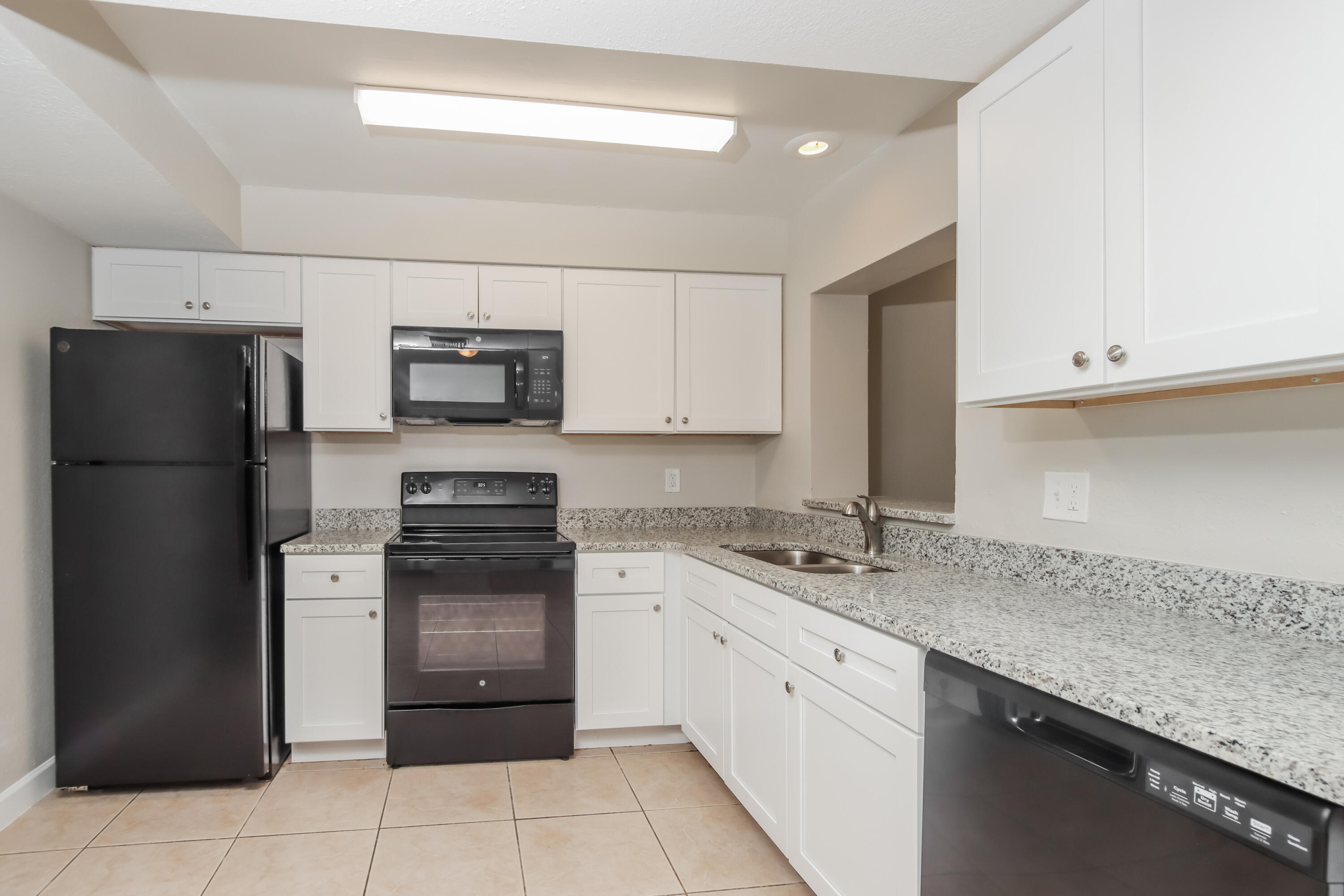 1195 Cotton Road Northeast Palm Bay, FL 32905 - Photo 6 of 17 a kitchen with a sink stove and refrigerator
