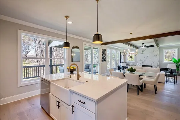 a kitchen with a sink a counter top space and living room view
