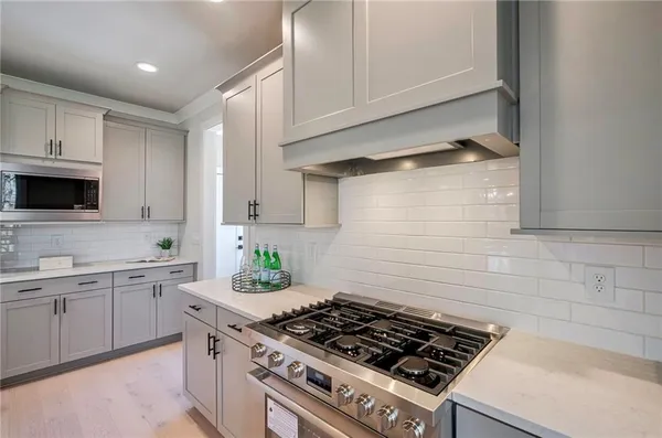a kitchen with stainless steel appliances a sink a stove and cabinets