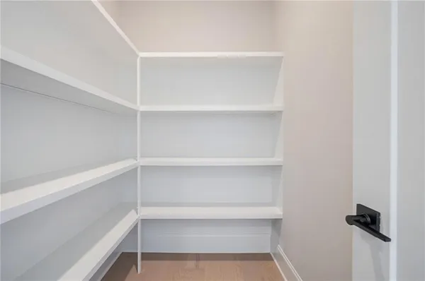 a view of walk in closet with empty racks