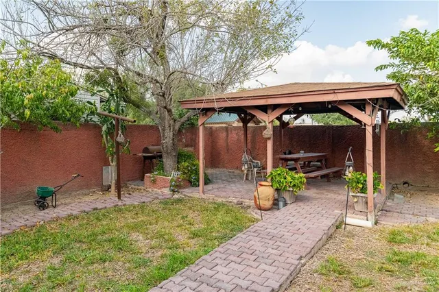 a view of a patio with table and chairs under an umbrella