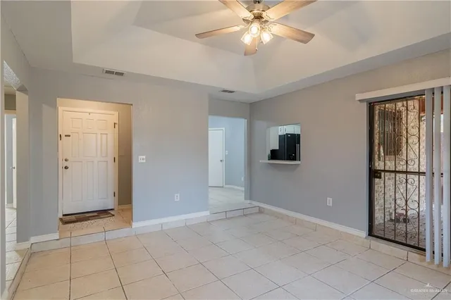 an empty room with fan and windows