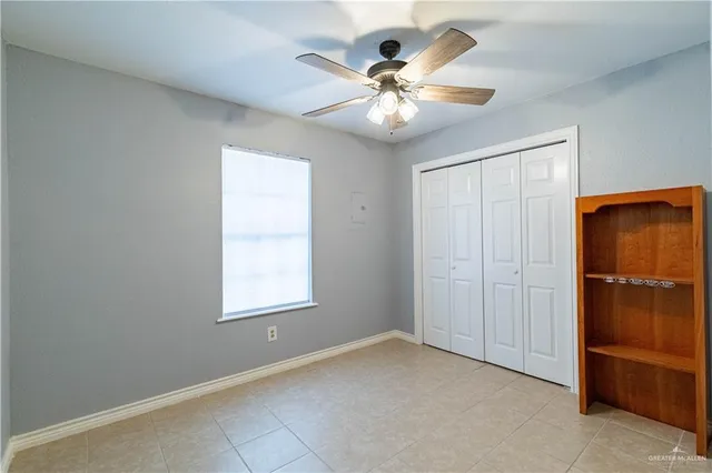 an empty room with closet and chandelier fan