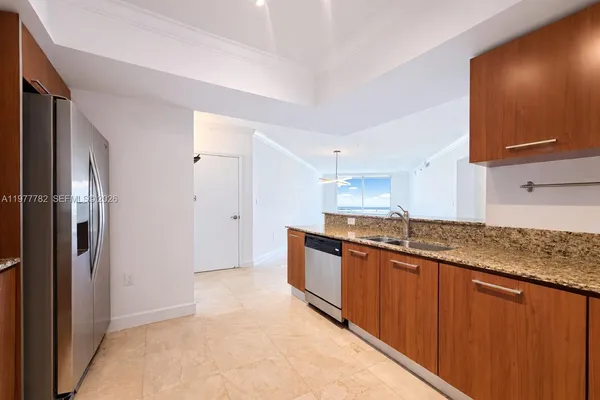 a large kitchen with granite countertop a sink and stainless steel appliances