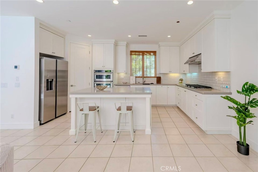 141 Dolci Irvine, CA 92602 - Photo 6 of 13 a kitchen with white cabinets and refrigerator