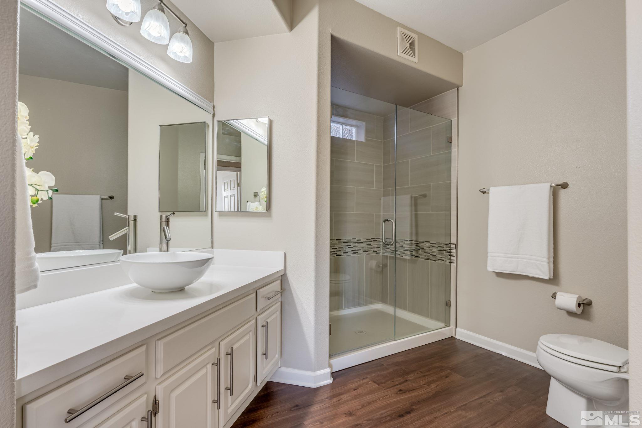 900 S Meadows, Unit 5313 Reno, NV 89521 - Photo 18 of 29 a bathroom with a granite countertop sink a toilet a mirror and shower