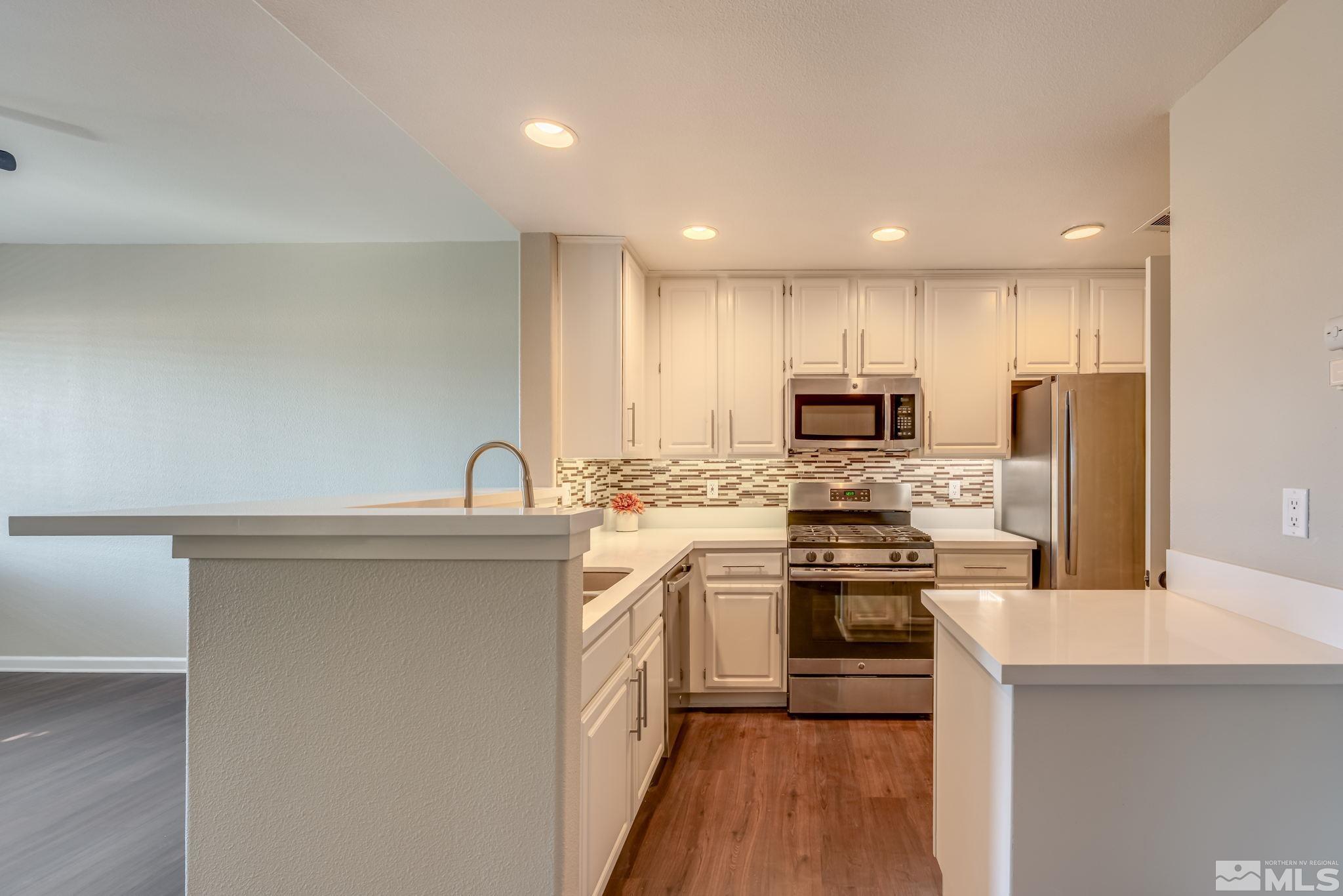 900 S Meadows, Unit 5313 Reno, NV 89521 - Photo 6 of 29 a kitchen with stainless steel appliances granite countertop a stove top oven a sink and a refrigerator