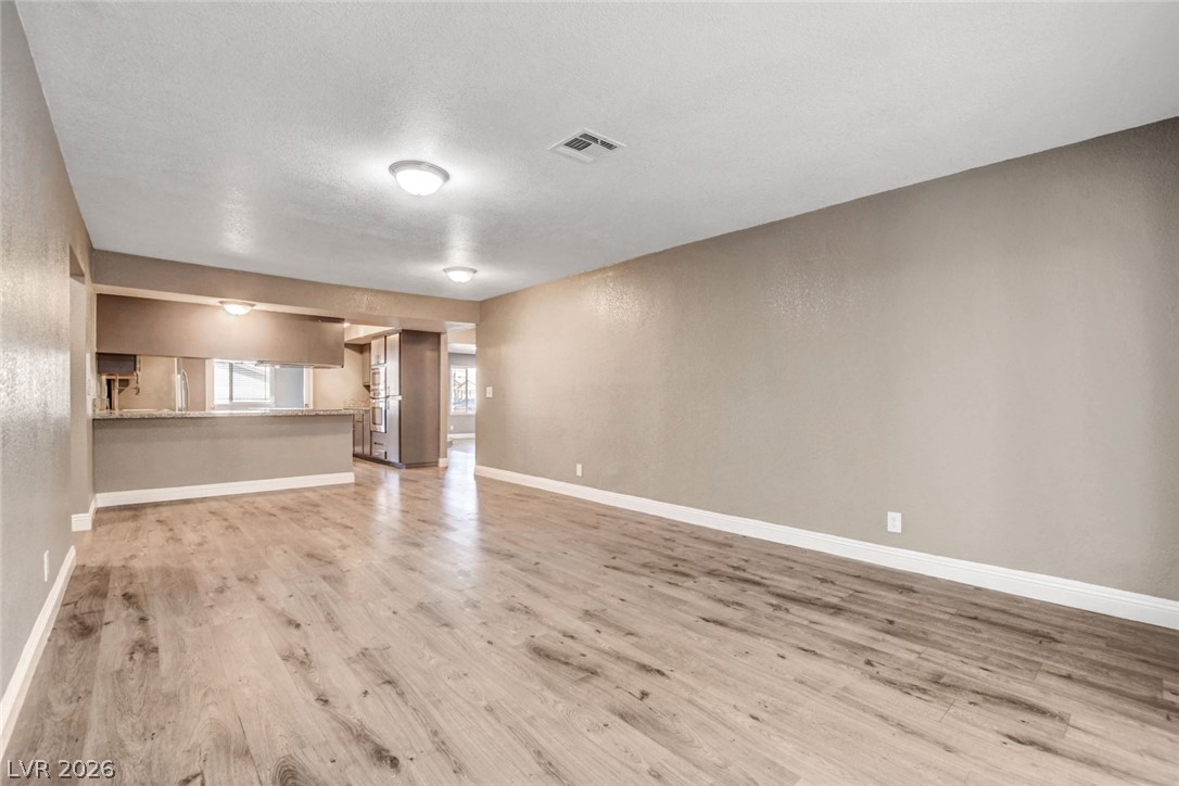 4367 South Mojave Road Las Vegas, NV 89121 - Photo 17 of 53 A well-lit interior space features sleek wood flooring, a kitchen pass-through, and recessed lighting.