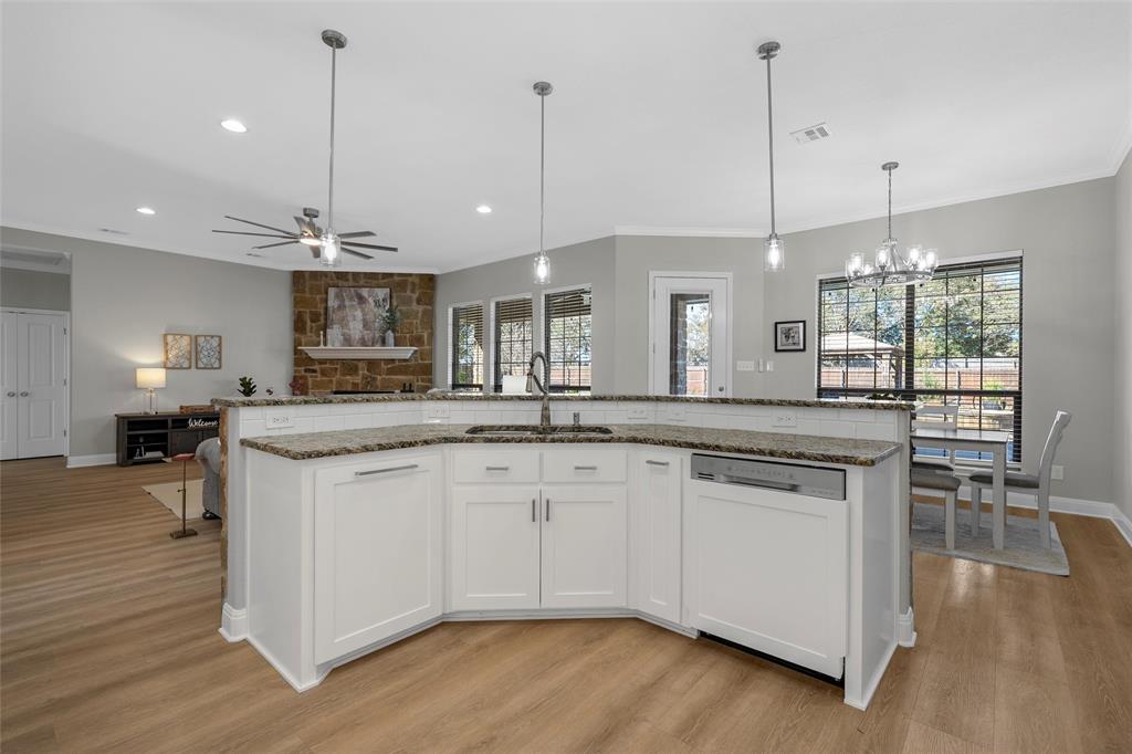 404 Casa Del Rancho Road Lorena, TX 76655 - Photo 7 of 36 a kitchen with stainless steel appliances granite countertop wooden floors and white cabinets