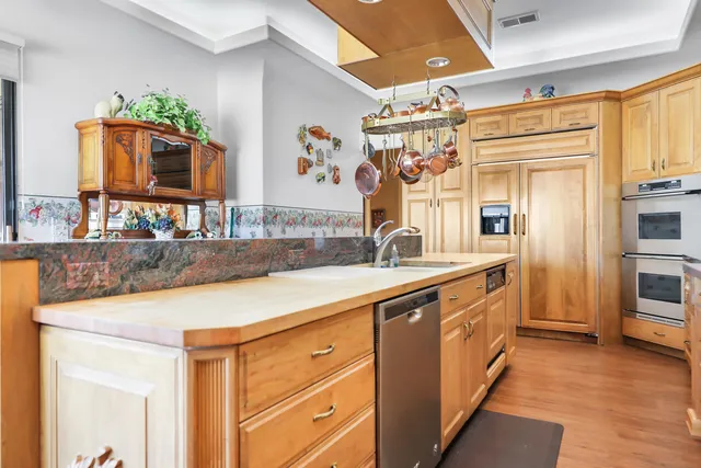 a kitchen with stainless steel appliances granite countertop a sink and wooden cabinets
