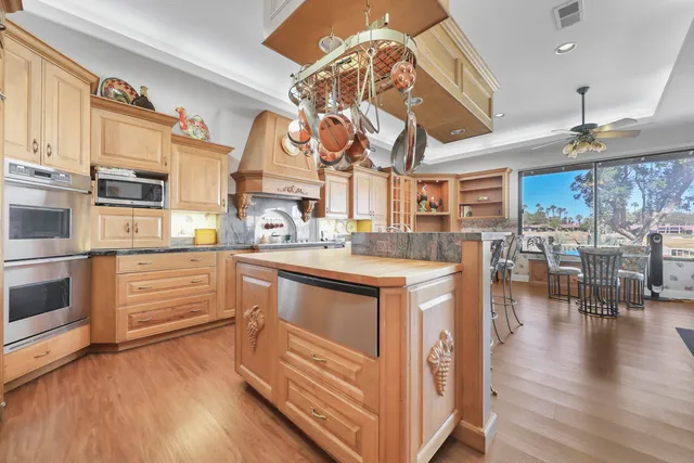 a kitchen with stainless steel appliances granite countertop a white cabinets and chandelier