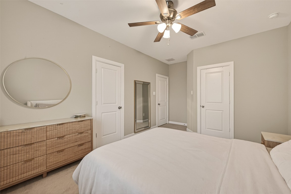 2706 Ripe Amber Cup Court Richmond, TX 77406 - Photo 28 of 50 a bedroom with a large bed and a chandelier