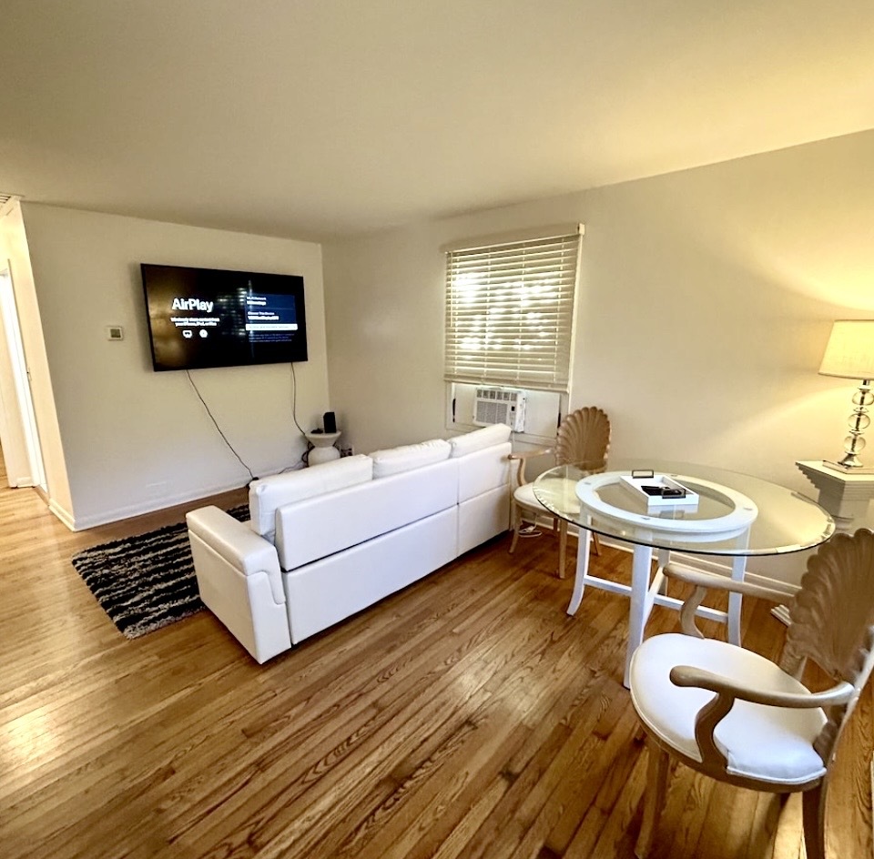 905 Rockland Road Lake Bluff, IL 60044 - Photo 7 of 16 a living room with a couch and a flat screen tv