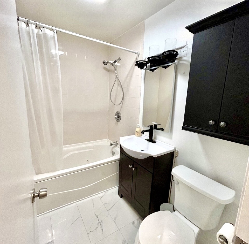 905 Rockland Road Lake Bluff, IL 60044 - Photo 10 of 16 a bathroom with a sink a toilet and shower