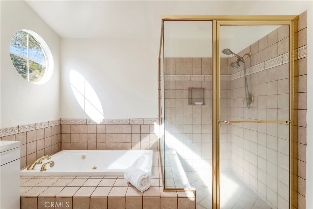 29033 Shadow Valley Lane Saugus, CA 91390 - Photo 35 of 73 a bathroom with a bathtub and shower