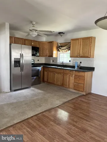 a kitchen with stainless steel appliances granite countertop a sink a stove and a refrigerator