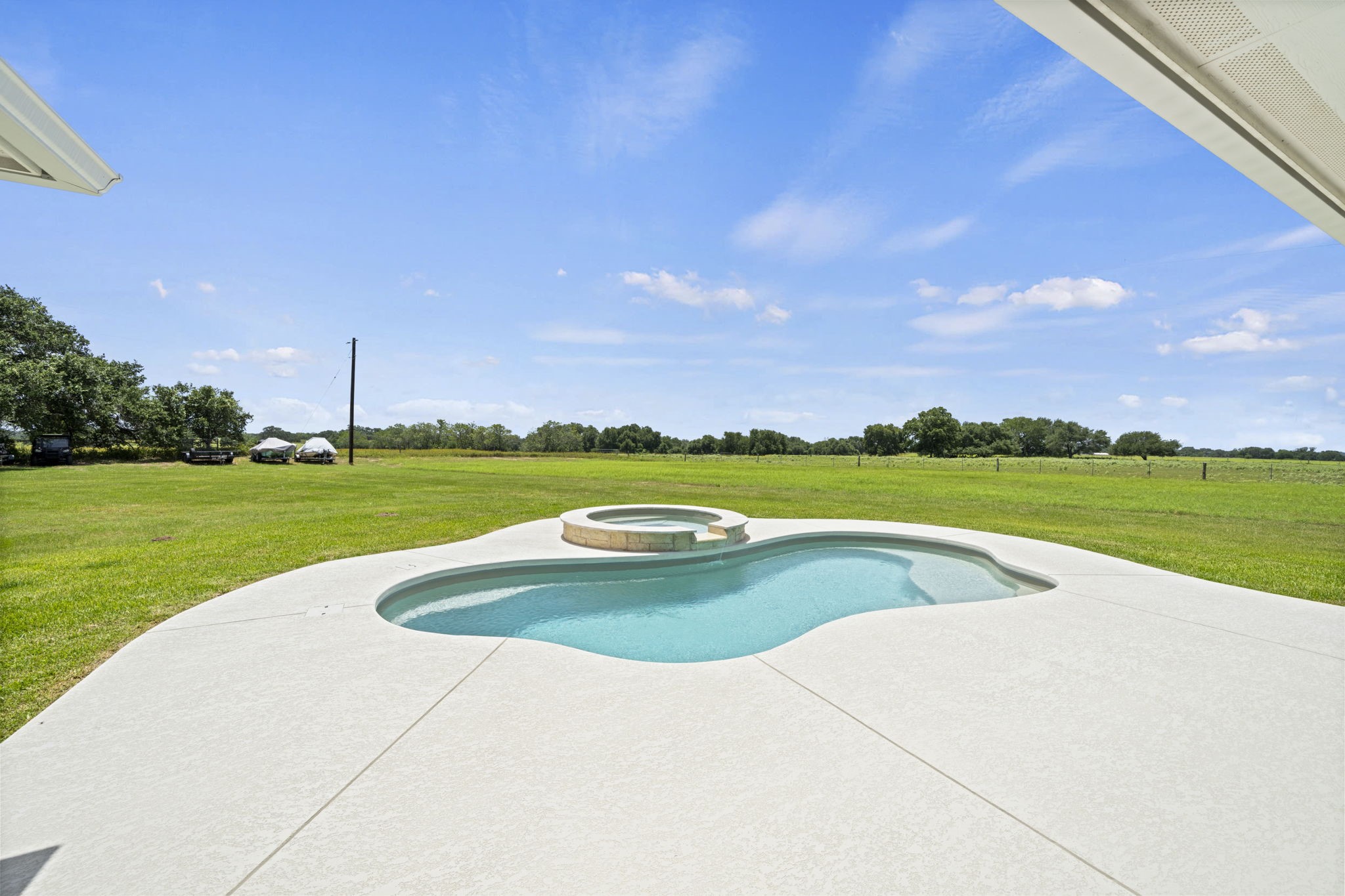 1655 Old Cuero Road Yoakum, TX 77995 - Photo 17 of 24 Step outside to your own private backyard retreat featuring a sparkling freeform pool with an elevated spa, perfectly positioned to take in breathtaking panoramic views of the surrounding countryside.