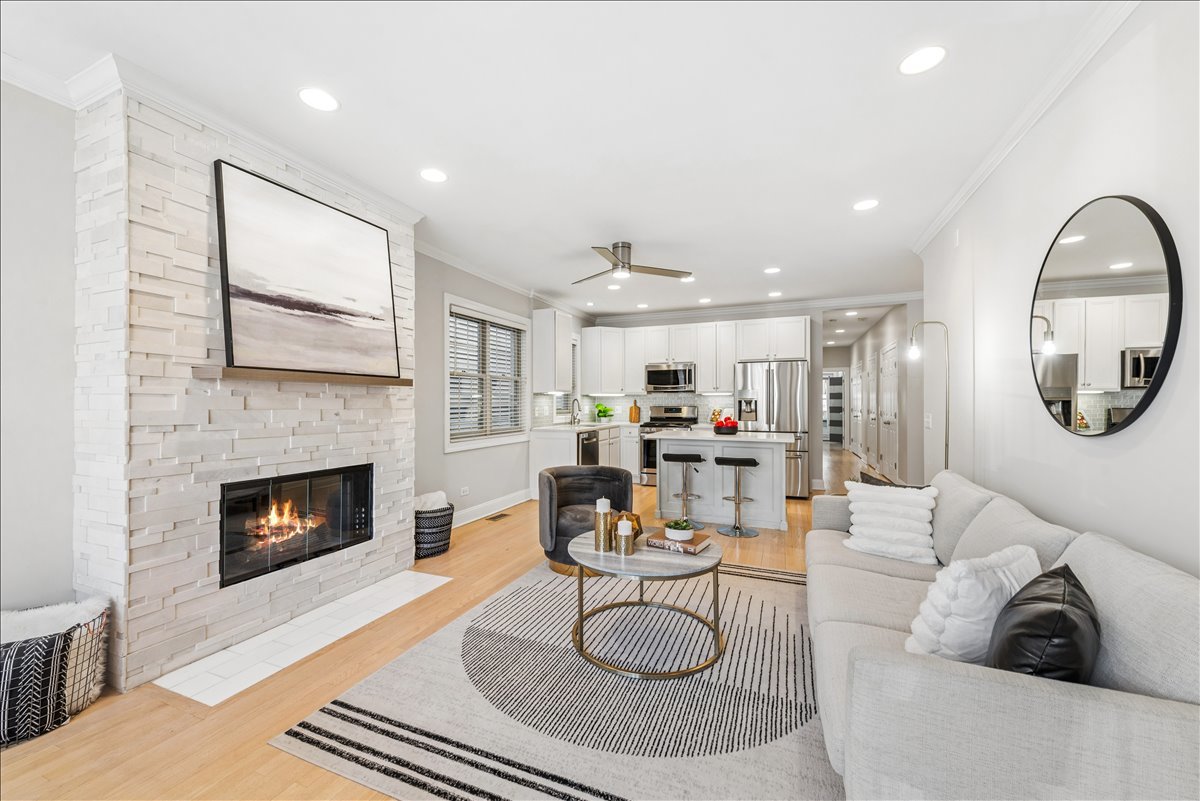 2838 North Damen Avenue, Unit 1 Chicago, IL 60618 - Photo 5 of 25 a living room with furniture a fireplace and kitchen view