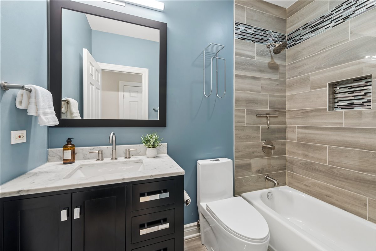 2838 North Damen Avenue, Unit 1 Chicago, IL 60618 - Photo 8 of 25 a bathroom with a sink a toilet and shower