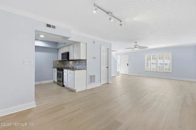 a view of a kitchen with a sink and a refrigerator