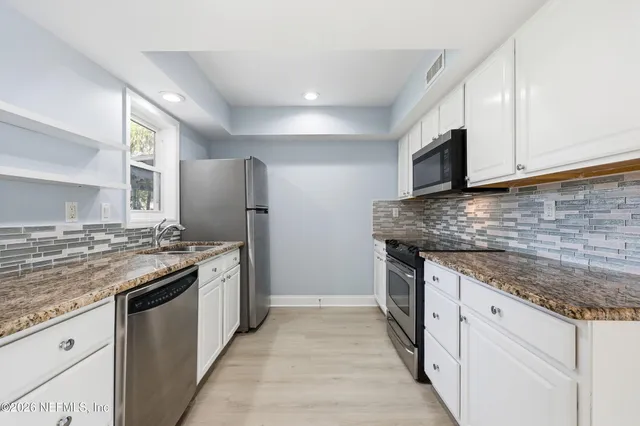 a kitchen with stainless steel appliances granite countertop a stove and a sink