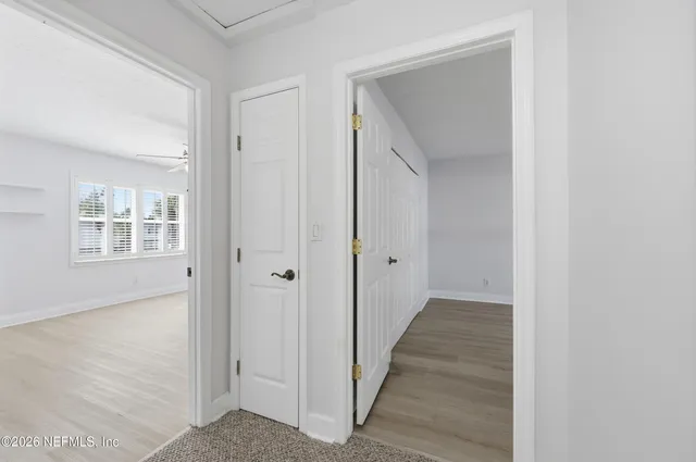 a view of a hallway with wooden floor and closet