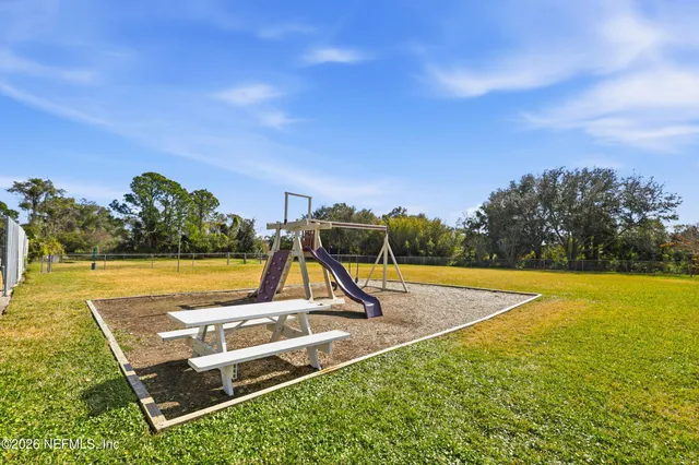 a view of a swimming pool with a yard and plants