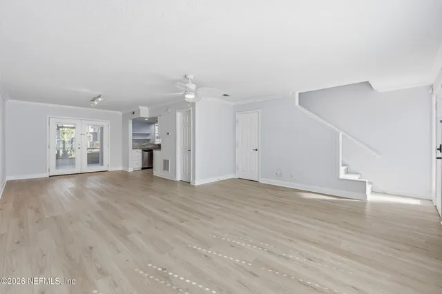 a view of empty room with wooden floor