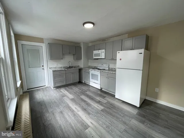 a kitchen with cabinets and wooden floor