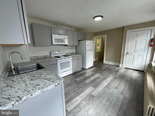 a kitchen with stainless steel appliances granite countertop a sink stove refrigerator and cabinets