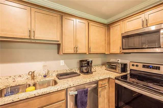 a kitchen with stainless steel appliances granite countertop a sink and a microwave