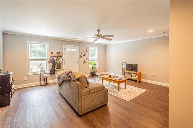a living room with furniture and a wooden floor