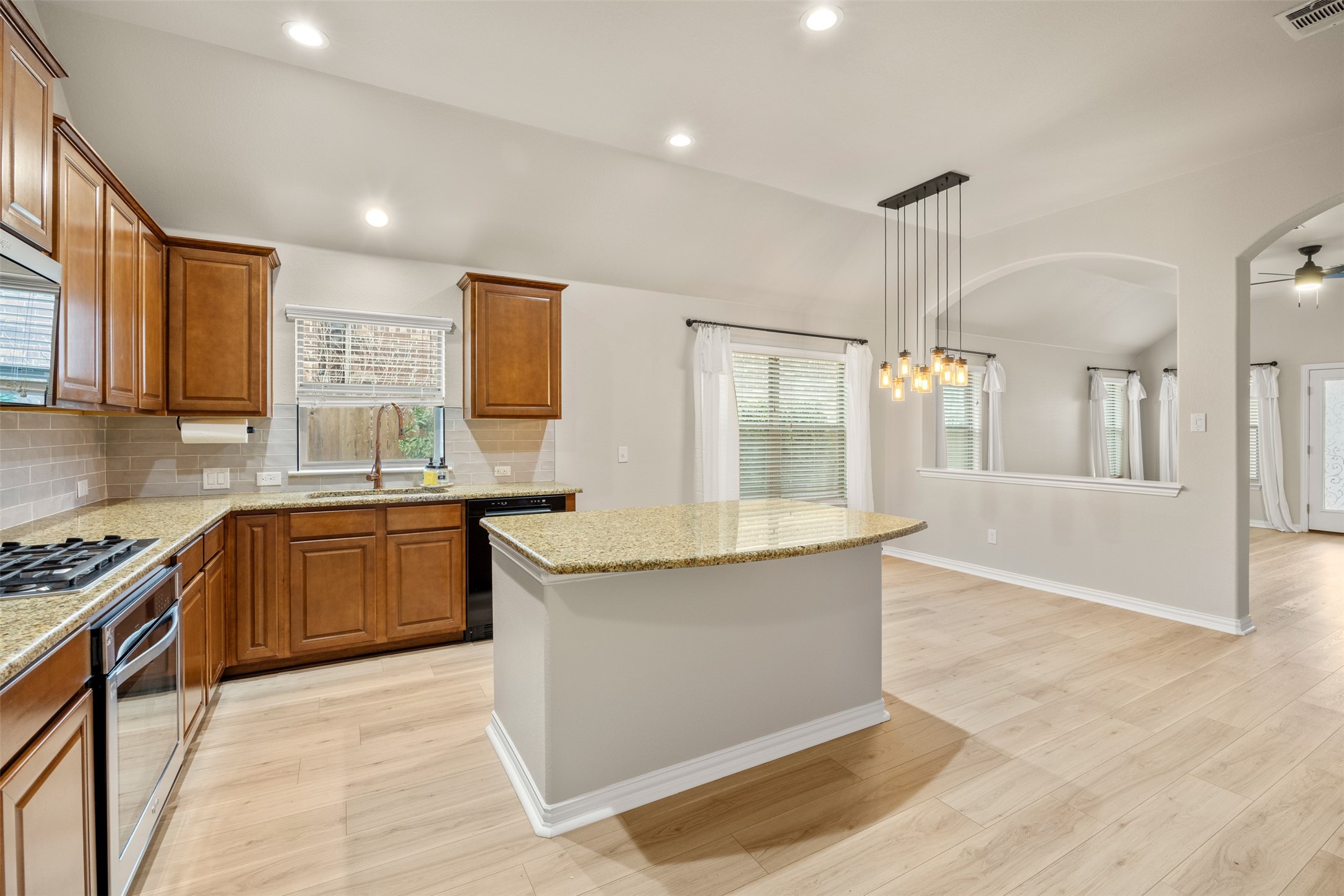 249 Saffron Springs Buda, TX 78610 - Photo 7 of 21 a large kitchen with granite countertop a sink and a stove top oven