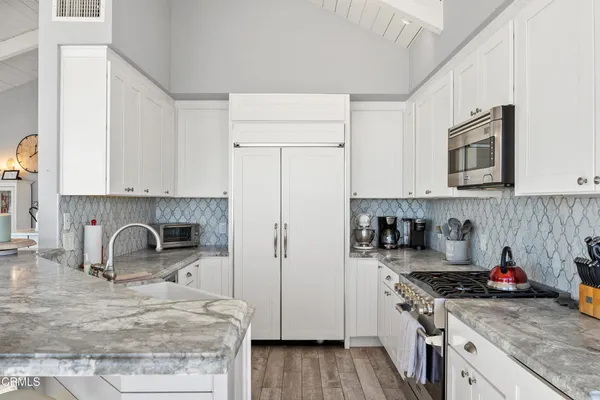 a kitchen with granite countertop a sink stove and cabinets