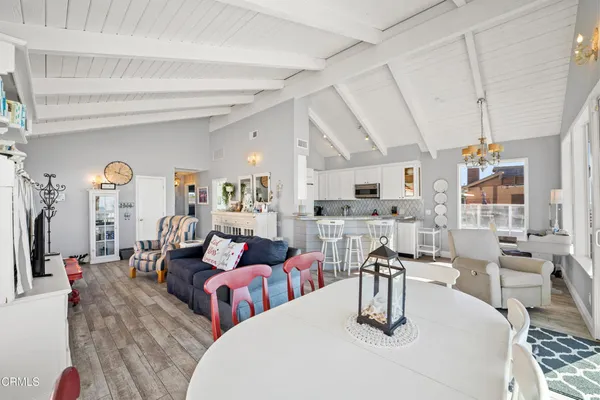 a living room with lots of white furniture and a table