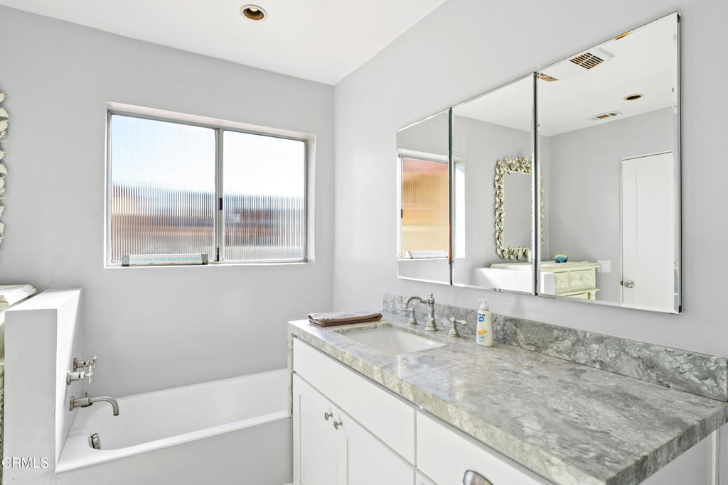 2405 Ocean Drive Oxnard, CA 93035 - Photo 20 of 40 a bathroom with a granite countertop sink mirror and a bathtub