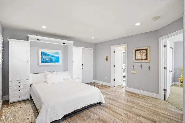 a bedroom with a bed and painting on the wall