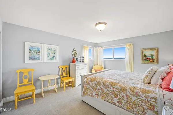 a spacious bedroom with a bed and a chair
