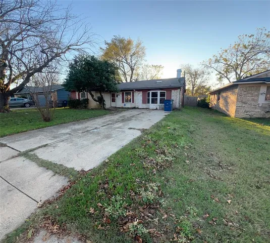 a view of a house with a yard and large tree