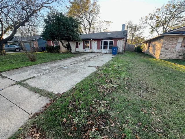 front view of a house with a yard and potted plants