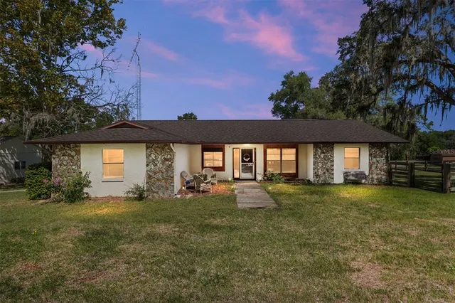 a view of a house with table and chairs under an umbrella