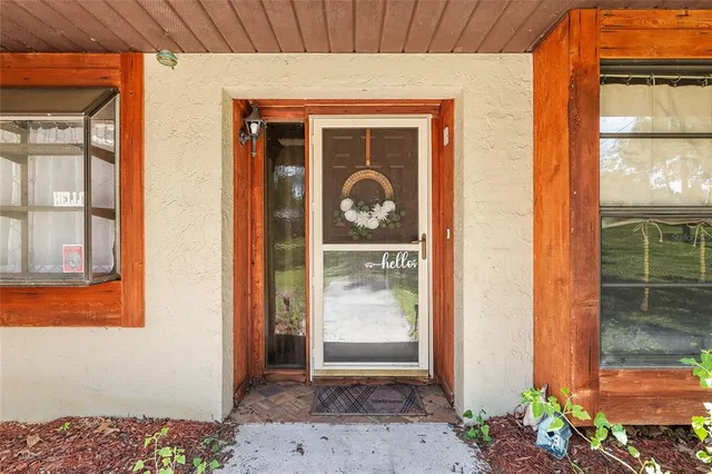 a front view of a house with a potted plant and floor to ceiling windows