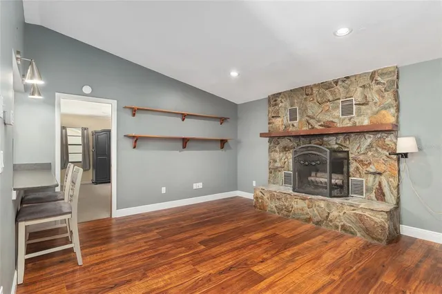 a view of a livingroom with wooden floor and a fireplace